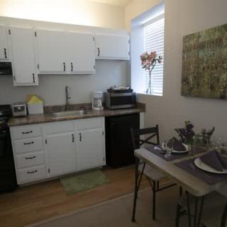 A cozy kitchen with white cabinetry and a small dining area.