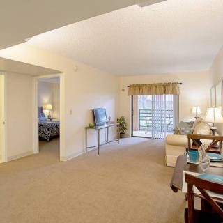 A spacious living room with a dining area and a TV in an apartment.