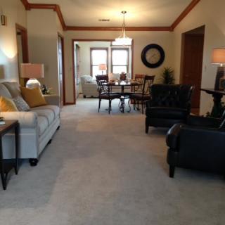 A spacious living and dining area featuring comfortable seating, warm lighting, and elegant decor.