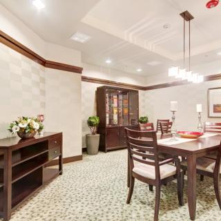 A stylish and elegantly decorated dining room with a wooden table and chairs, featuring a chandelier and decorative elements.