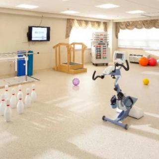 A rehabilitation therapy room equipped with various exercise apparatus and tools.