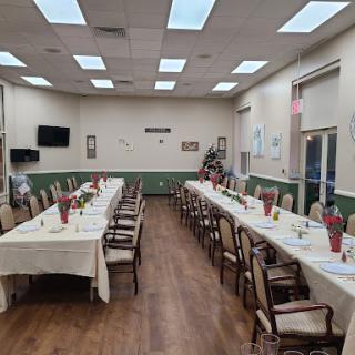 A spacious dining area set up for an event, featuring neatly arranged tables and chairs.