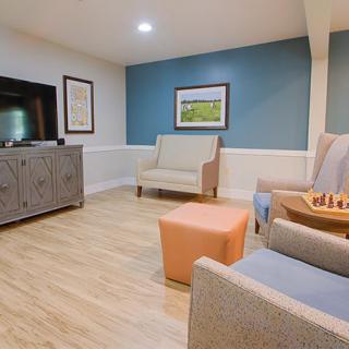 A cozy living room with modern furniture, featuring a television, comfortable seating, and tasteful decor.