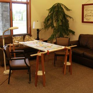 A cozy living room setup with a sofa, chairs, and a table supported by adjustable stands.