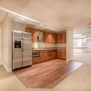 A modern kitchen setup with wooden cabinets and a stainless steel refrigerator.
