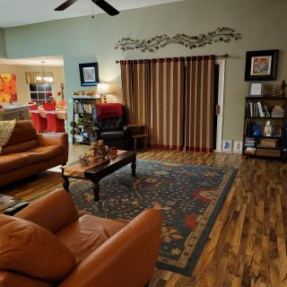 A cozy living room with leather sofas, a coffee table, and a decorative rug.