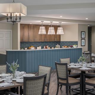 A modern dining area with elegantly set tables and pendant lighting.