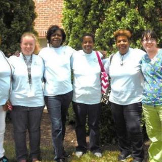A group of six people standing together outside, smiling for the camera.