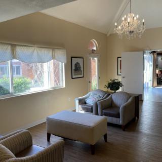 A cozy living room with comfortable seating and elegant chandelier lighting.