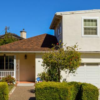 A suburban two-story house with well-maintained landscaping.