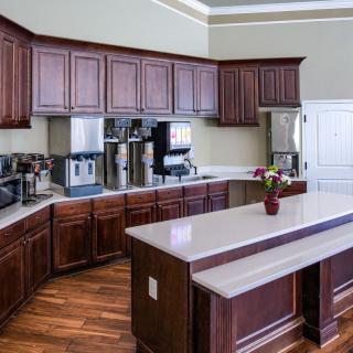 A modern kitchen with wooden cabinets, stainless steel appliances, and a central island.