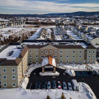 Aerial view of a hotel surrounded by a snowy residential area.