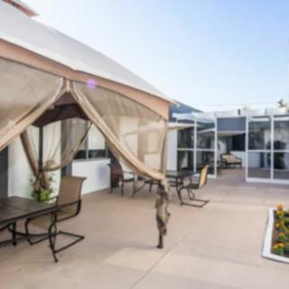 A spacious patio with comfortable outdoor seating and a canopy for shade.