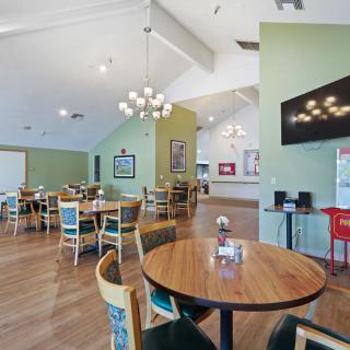 A cozy restaurant interior with neatly arranged tables and chairs, adorned with warm lighting.