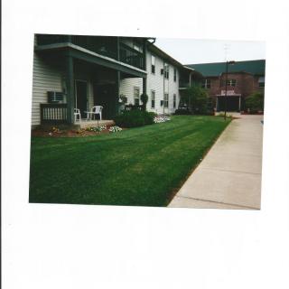 A residential house with a green lawn and driveway.