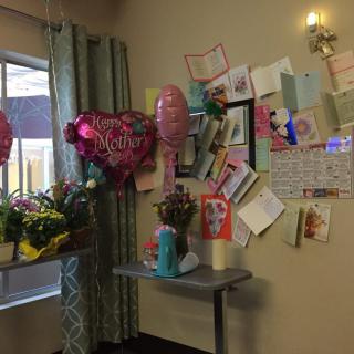A room corner decorated with balloons, flowers, and cards, creating a festive atmosphere.