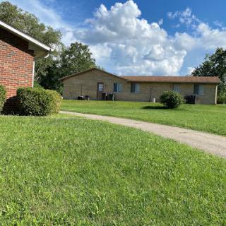 A serene residential scene with well-maintained grass and a clear blue sky.