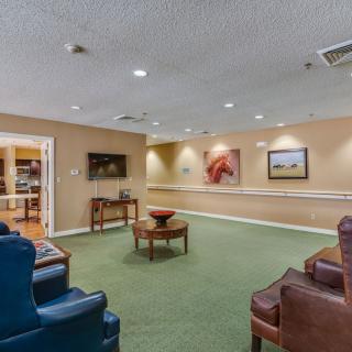 A cozy lobby area with comfortable seating, artwork on the walls, and a television.