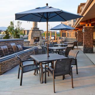 A patio area with tables, chairs, and umbrellas, perfect for outdoor dining on a sunny day.