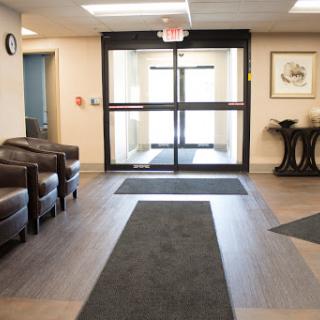 A spacious lobby area featuring comfortable seating and large glass doors.