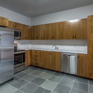 A modern kitchen with stainless steel appliances and wooden cabinets.