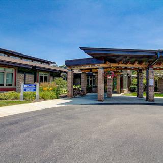 Modern healthcare facility entrance surrounded by landscaped gardens.