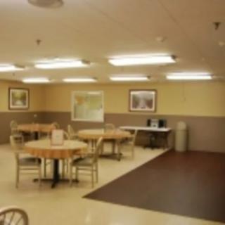 A clean and well-lit dining area with tables and chairs arranged neatly.
