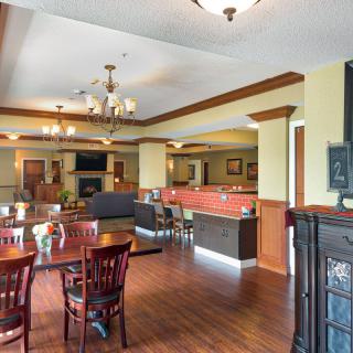 A spacious restaurant interior with wooden flooring and elegant lighting fixtures.