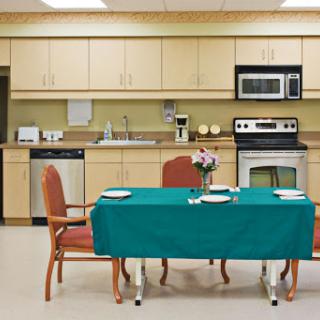 A cozy kitchen dining area featuring a green tablecloth, set for a meal.
