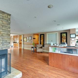 A modern interior reception area with a wooden floor and a fireplace.