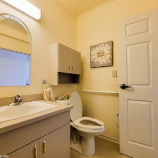 A well-lit and organized bathroom featuring a modern sink, toilet, and ample storage space.