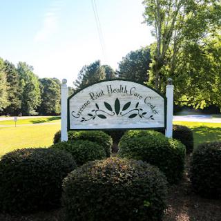 A welcoming sign for an outdoor community area, surrounded by lush greenery.
