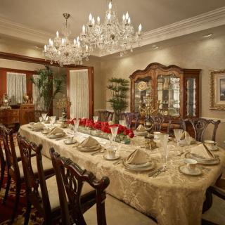An elegantly decorated dining room with a chandelier and a beautifully set table.
