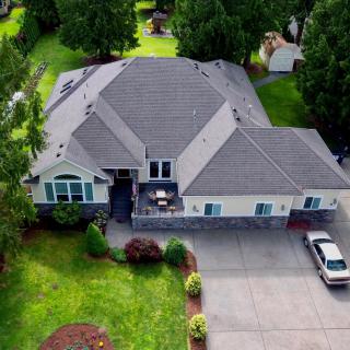 Aerial view of a spacious house with a well-maintained lawn and driveway.