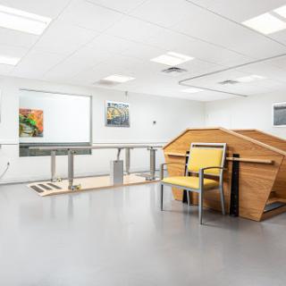 A modern interior space featuring minimalist furniture and artwork, possibly designed for therapeutic or medical purposes.