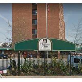 Entrance to a residential building with a green canopy and sign.