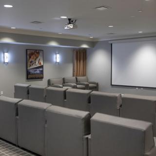 A cozy home theater room with comfortable seating and a large projector screen.