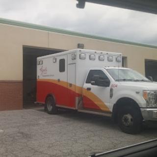 An ambulance parked outside a service building.
