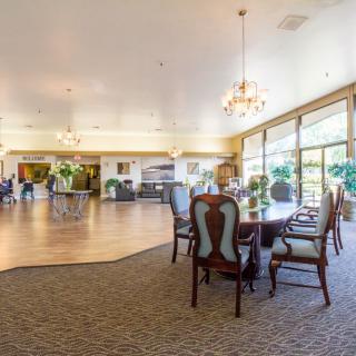 A spacious dining area with elegant furniture and large windows.
