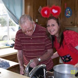 A cheerful moment in the kitchen with a loved one, sharing laughter and cooking.