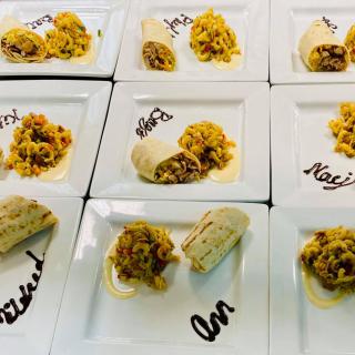 A gourmet presentation of plated tacos on several dishes, each labeled with different names.