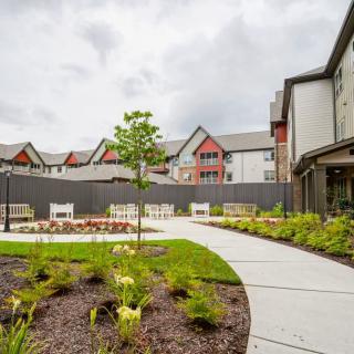 A well-maintained garden with a winding pathway adjacent to residential buildings.