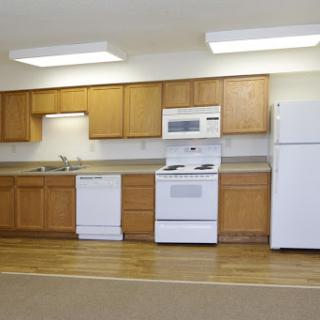 A modern kitchen featuring wooden cabinets, essential appliances, and a clean, organized layout.