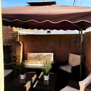 Cozy outdoor patio area with seating and a large umbrella.