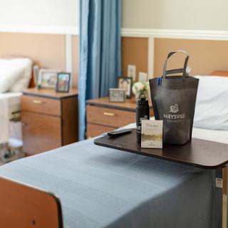 A cozy hospital room featuring a bedside tray with personal items and a clean, well-organized environment.