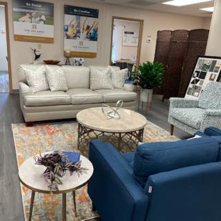 A cozy living room setup featuring a light beige sofa, blue armchairs, and a stylish coffee table.
