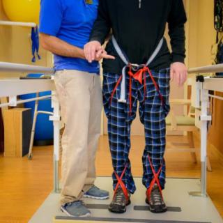 A physical therapist assists a patient using a walker in a rehabilitation session.