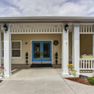 Front view of a house with a porch and double doors.