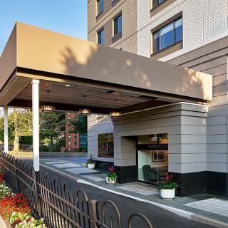 A hotel entrance with a canopy and well-maintained landscaping.