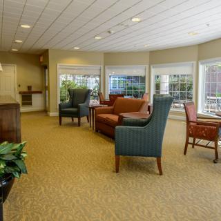 A comfortable living room with sofas and chairs, featuring large windows for natural light.